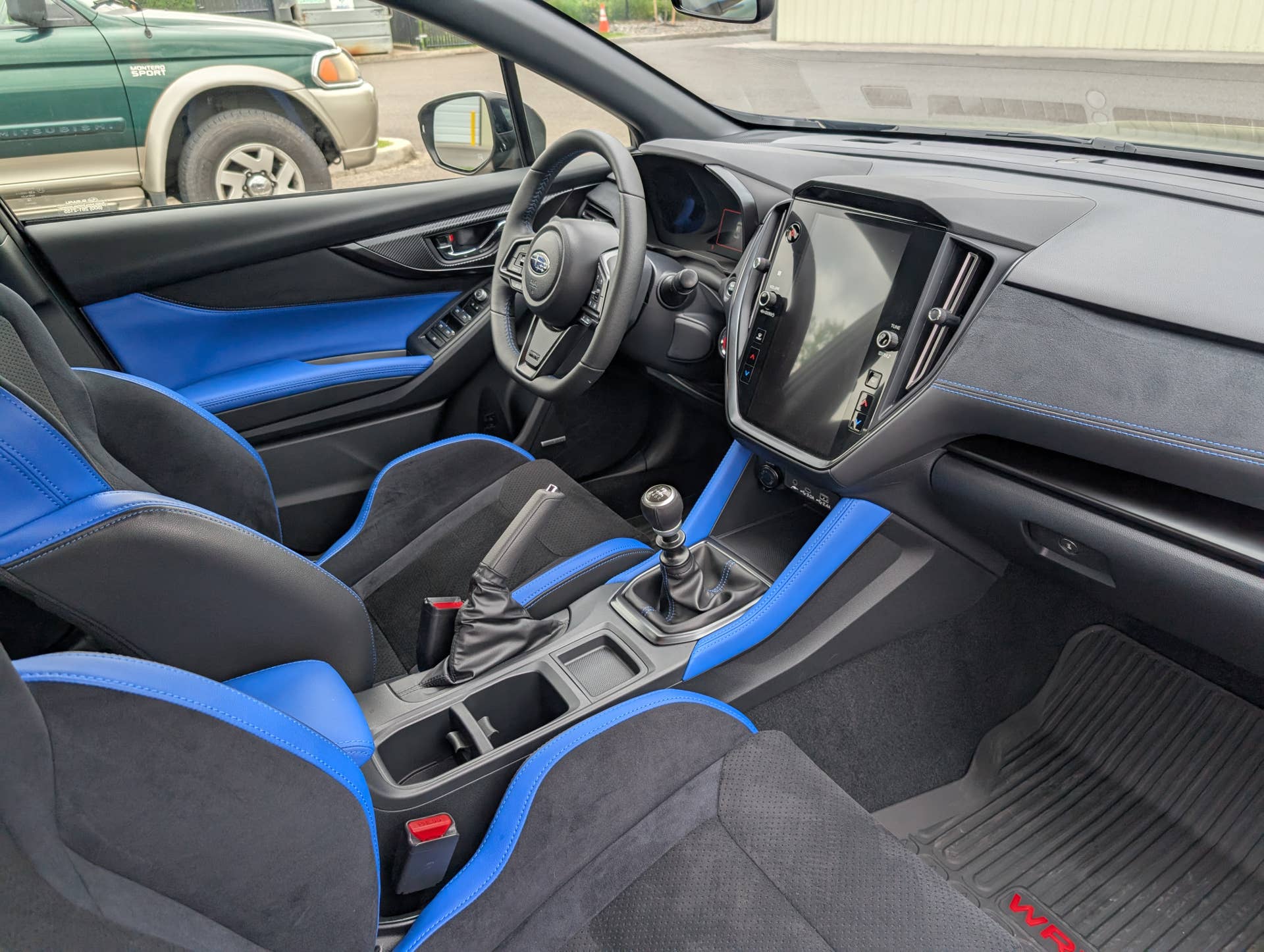 The interior of the 2025 Subaru WRX tS, noticeably lacking a center console armrest