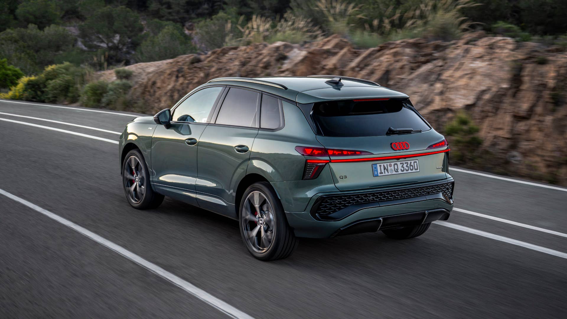 2026 Audi Q3 S Line Quattro in Sage Green rear angled view driving