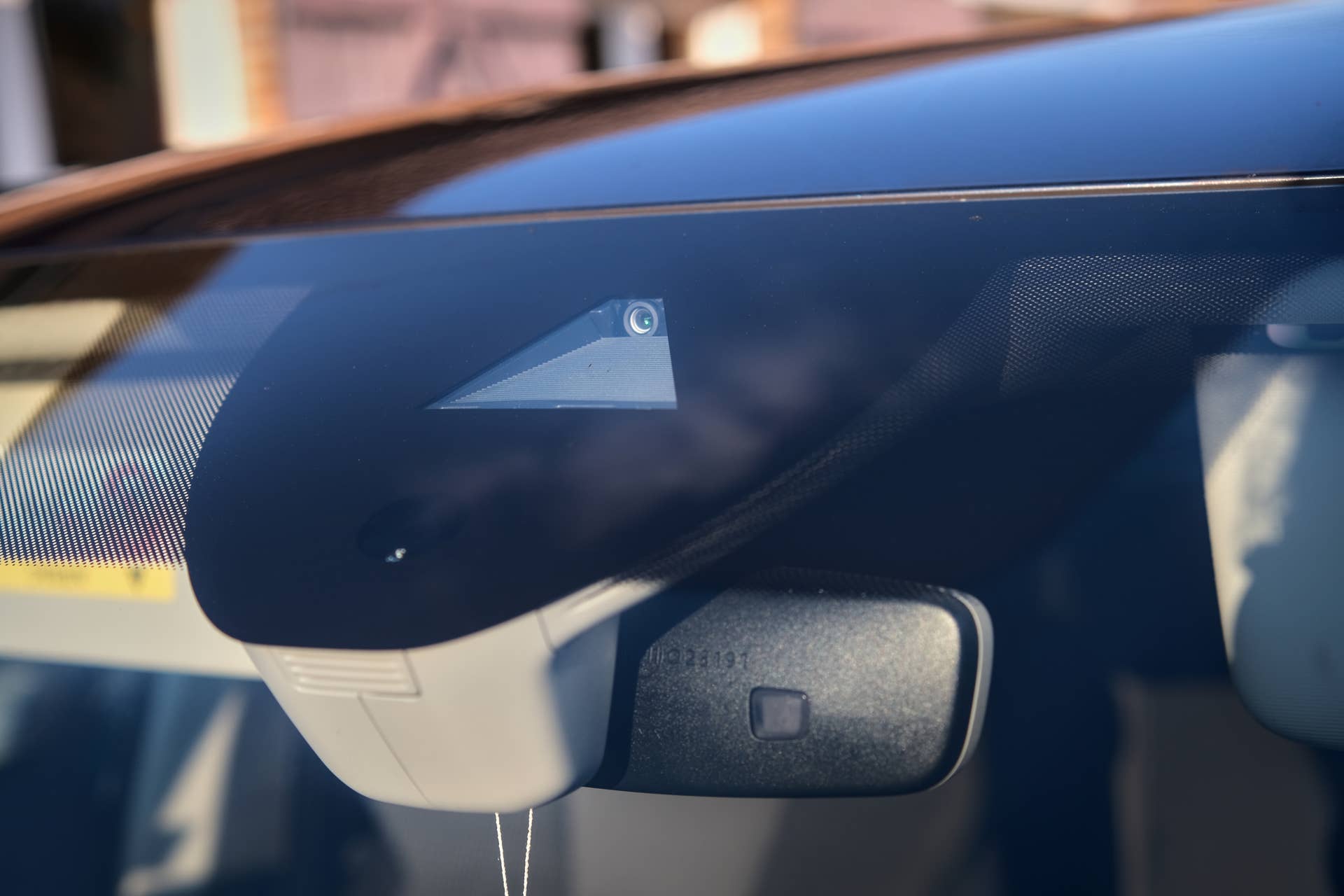 Close-up of a car's windshield with an integrated driver-assistance camera and sensor system