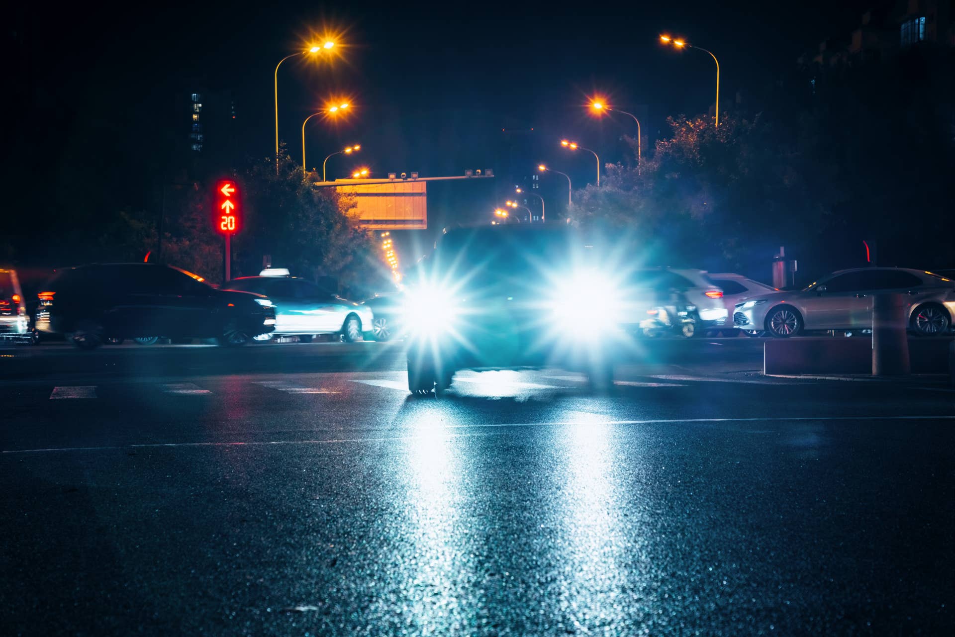 Illuminated headlights on an urban street at night