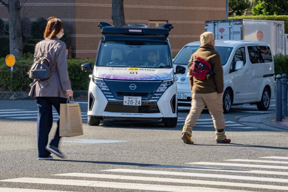 Nissan’s Serena shown navigating active streets with pedestrians in Yokohama’s Minato Mirai region.
