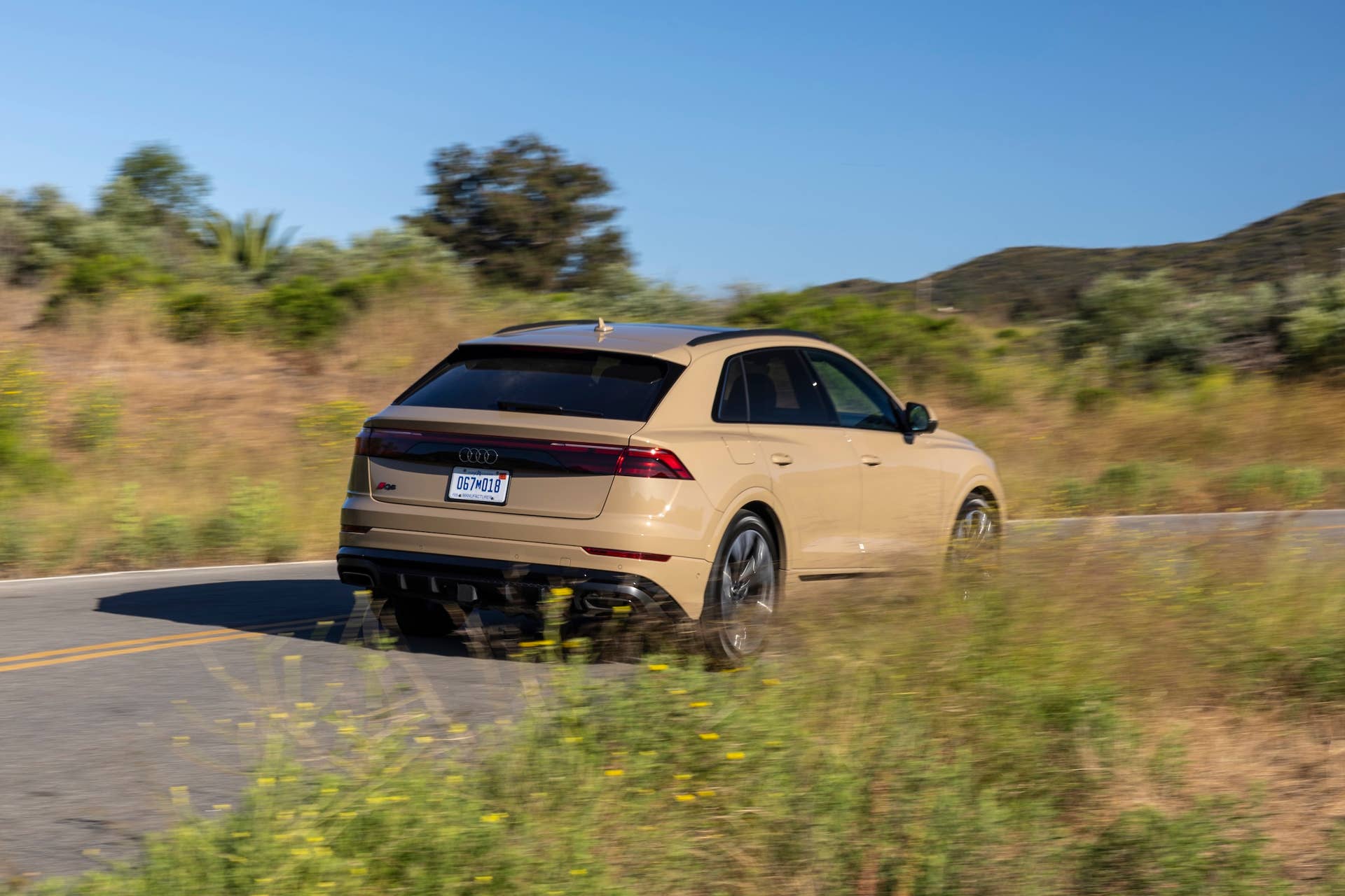2026 Audi Q8 beige rear angled view driving