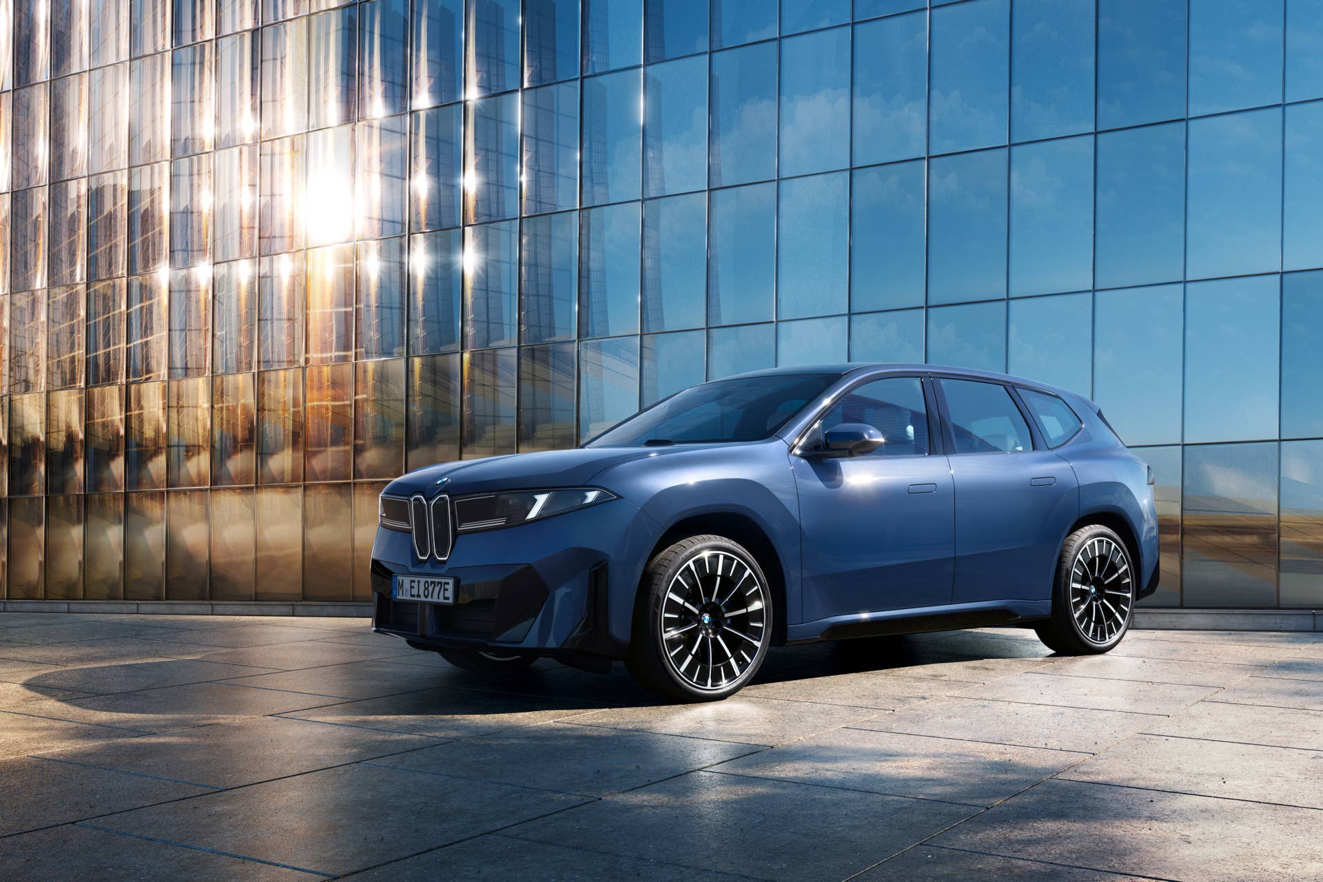 BMW iX3 - front 3-4 next to glass building