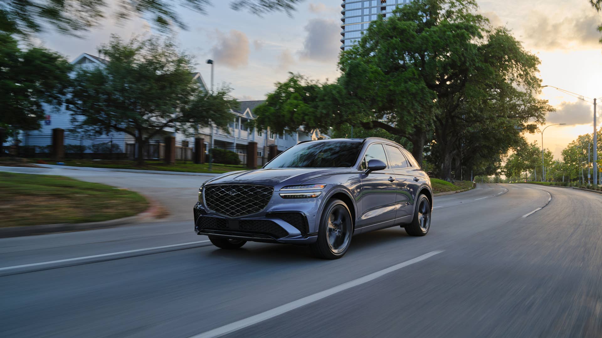The front end of the 2026 Genesis GV70 3.5T Sport Prestige AWD driving through town