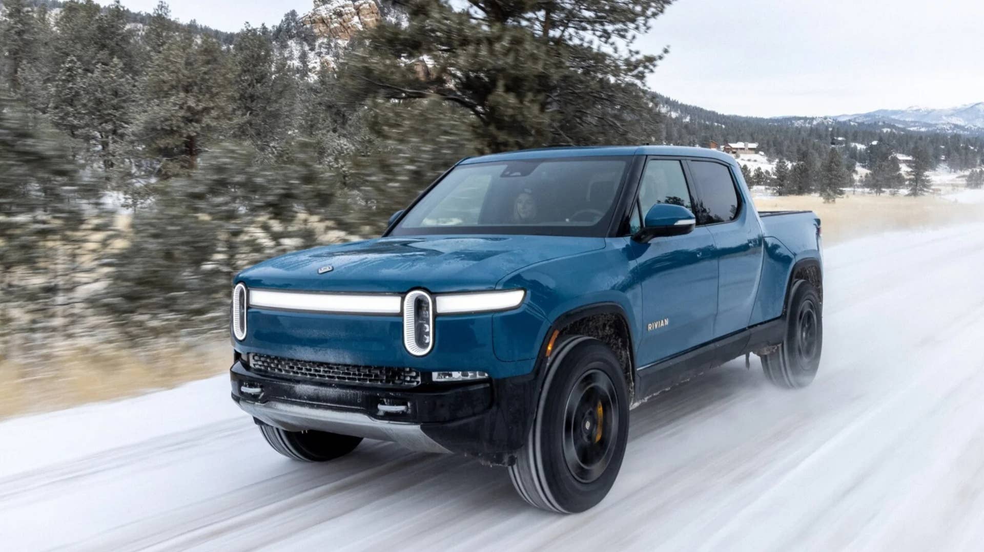 The Rivian R1T driving in the snow