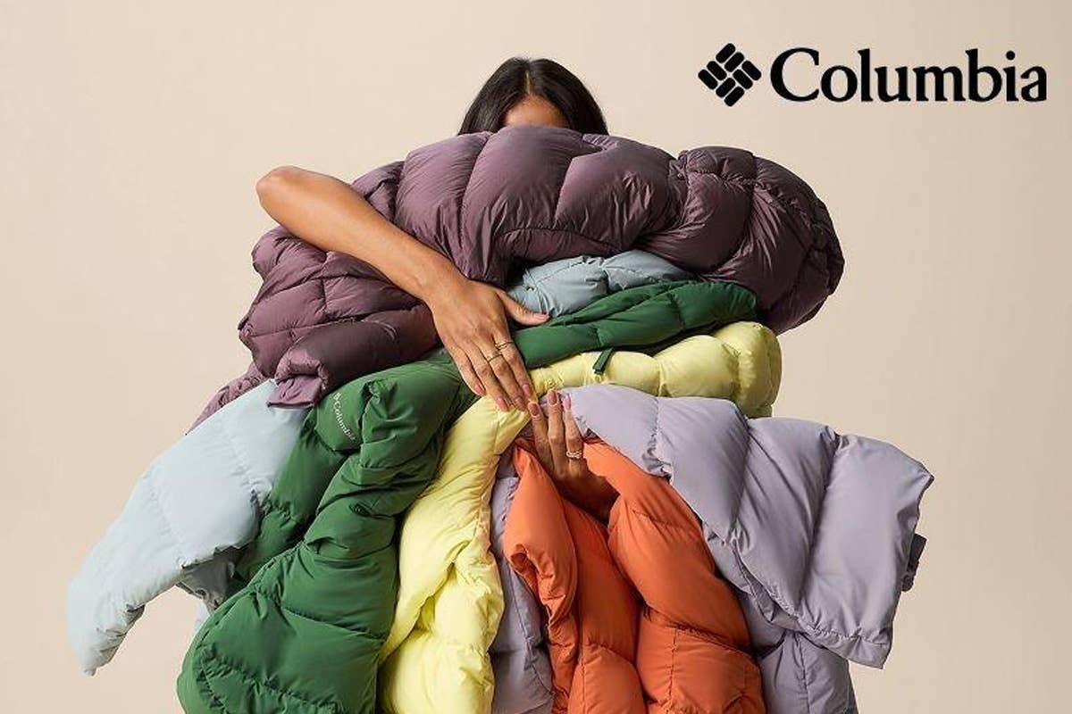 A woman holding Columbia jackets with the Columbia logo in the top right corner