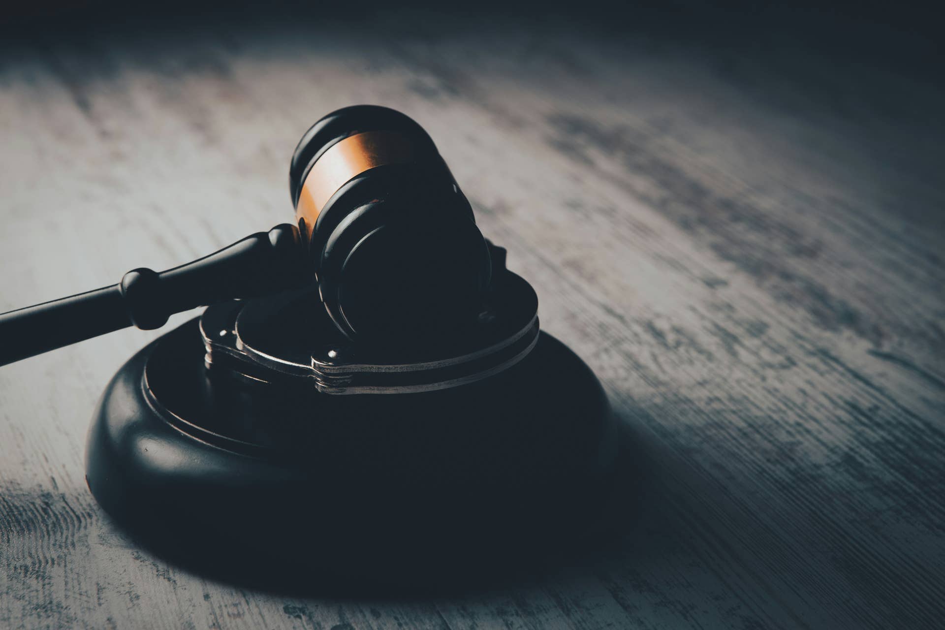 A judge's gaven on a wooden desk in a courtroom