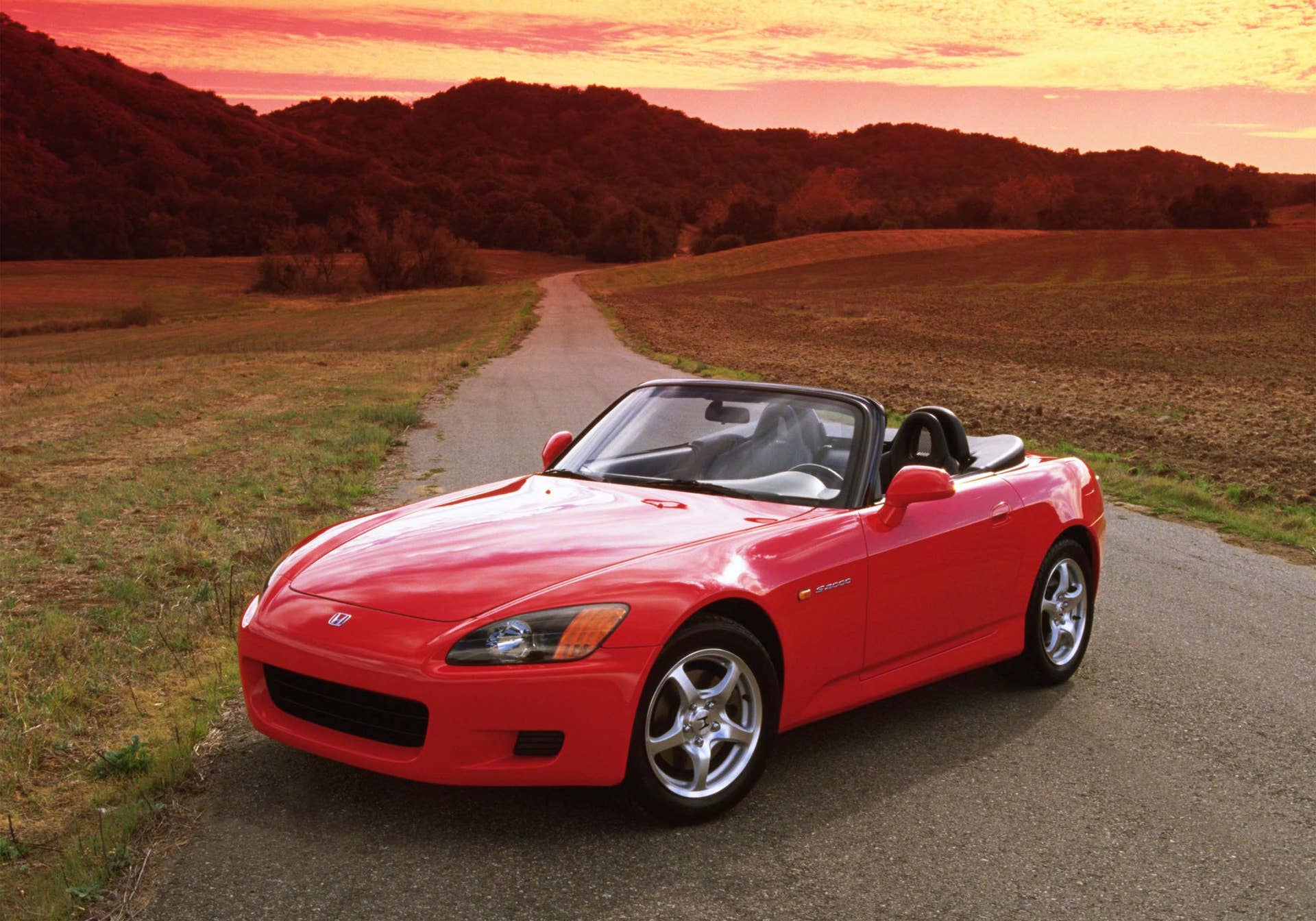 A static outdoor shot of a red Honda S2000 Roadster