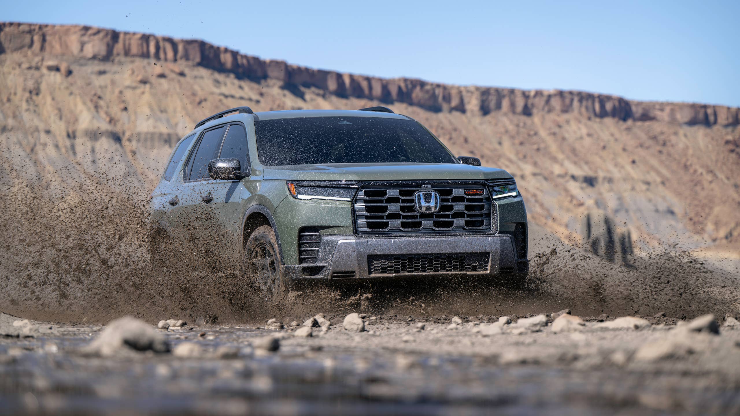 2026 Honda Pilot TrailSport front angled view dirt driving