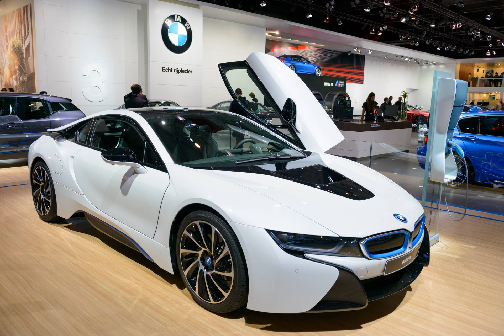 Brussels, Belgium - January 14, 2014: BWW i8 Hybrid sports car on display at the 2014 Brussels motor show. The BMW i8, first introduced as the BMW Concept Vision Efficient Dynamics, is a plug-in hybrid. People in the background are looking at the cars.