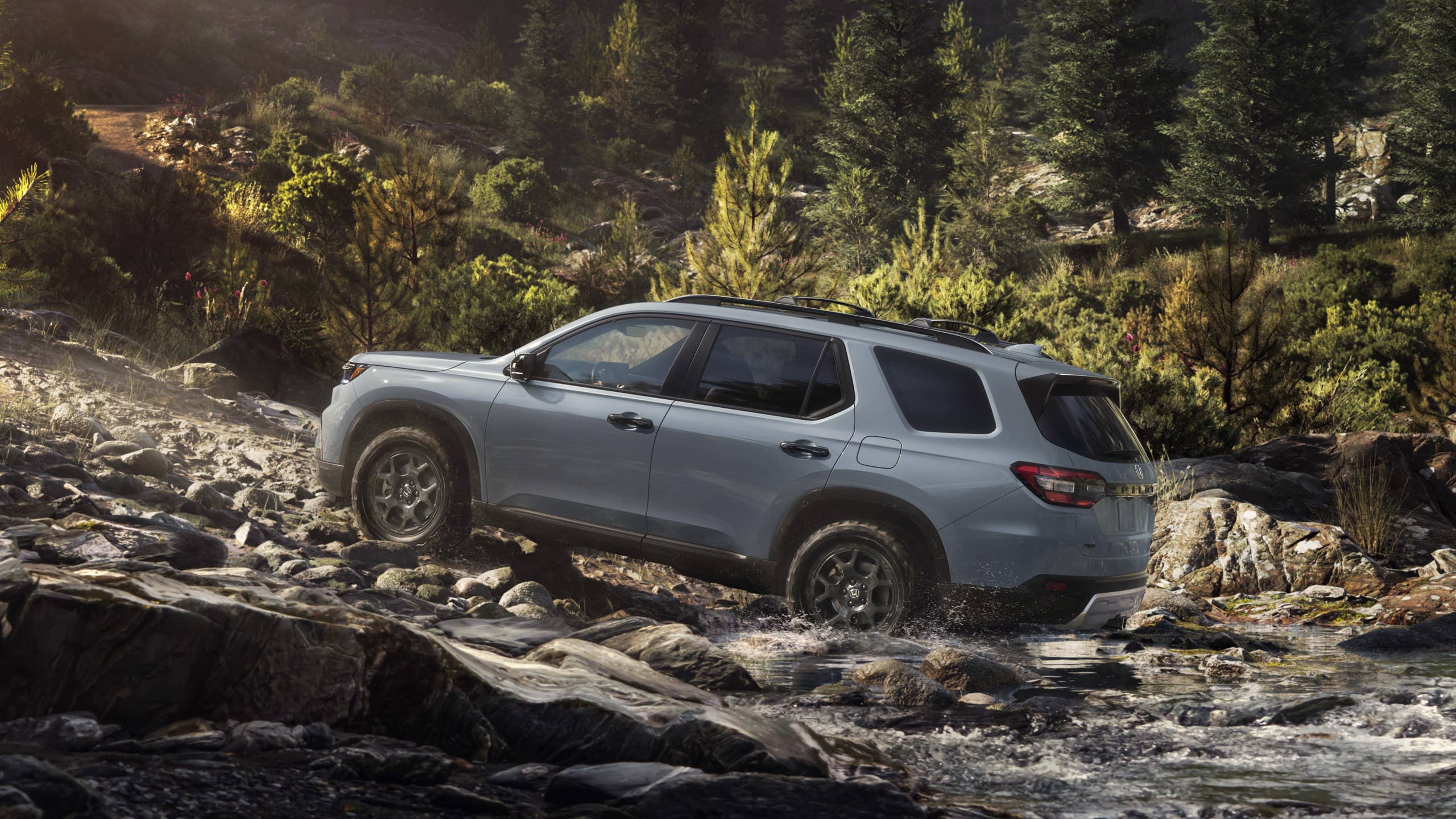 2026 Honda Pilot TrailSport rear angled view off-road driving