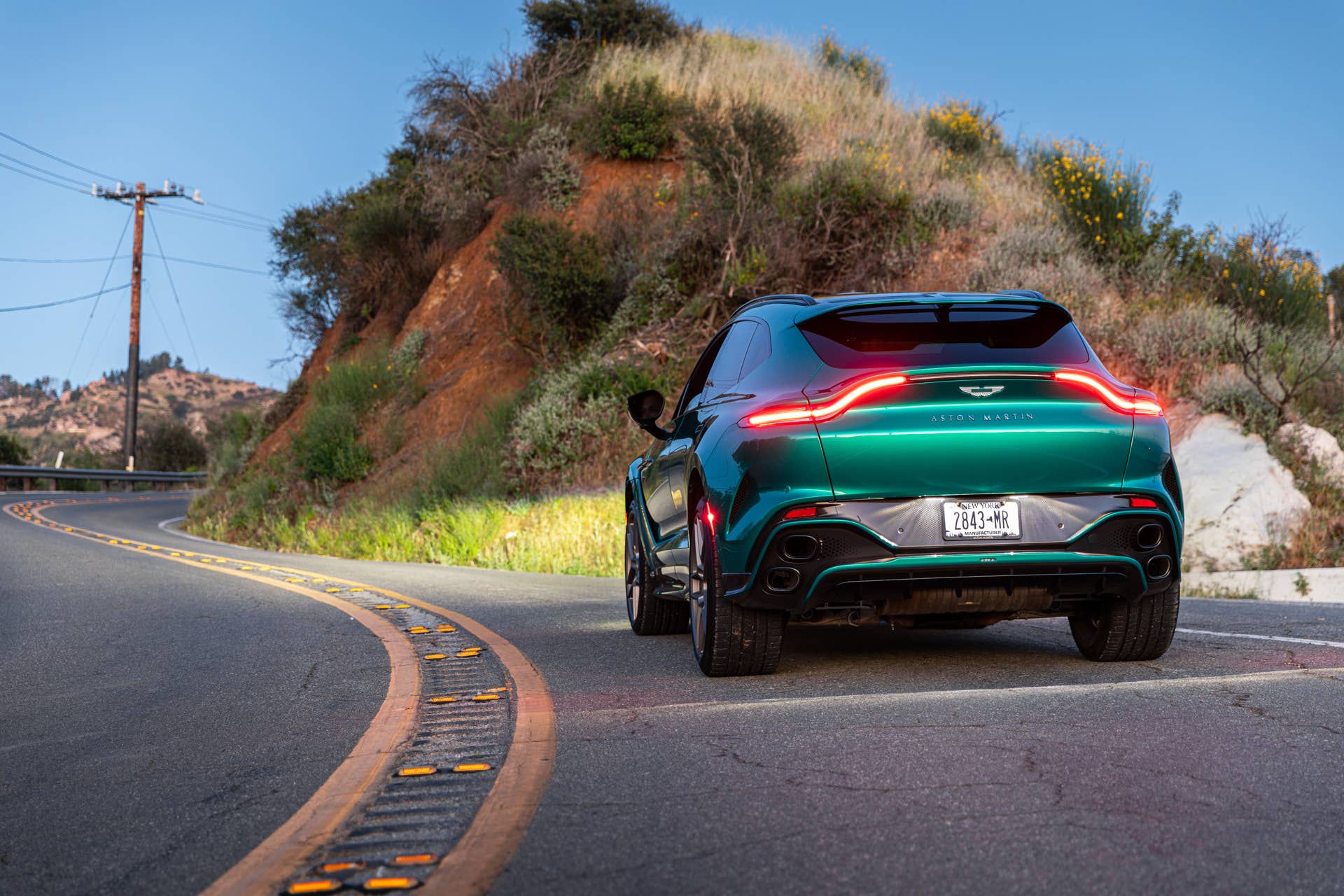 2026 Aston Martin DBX S green rear view driving