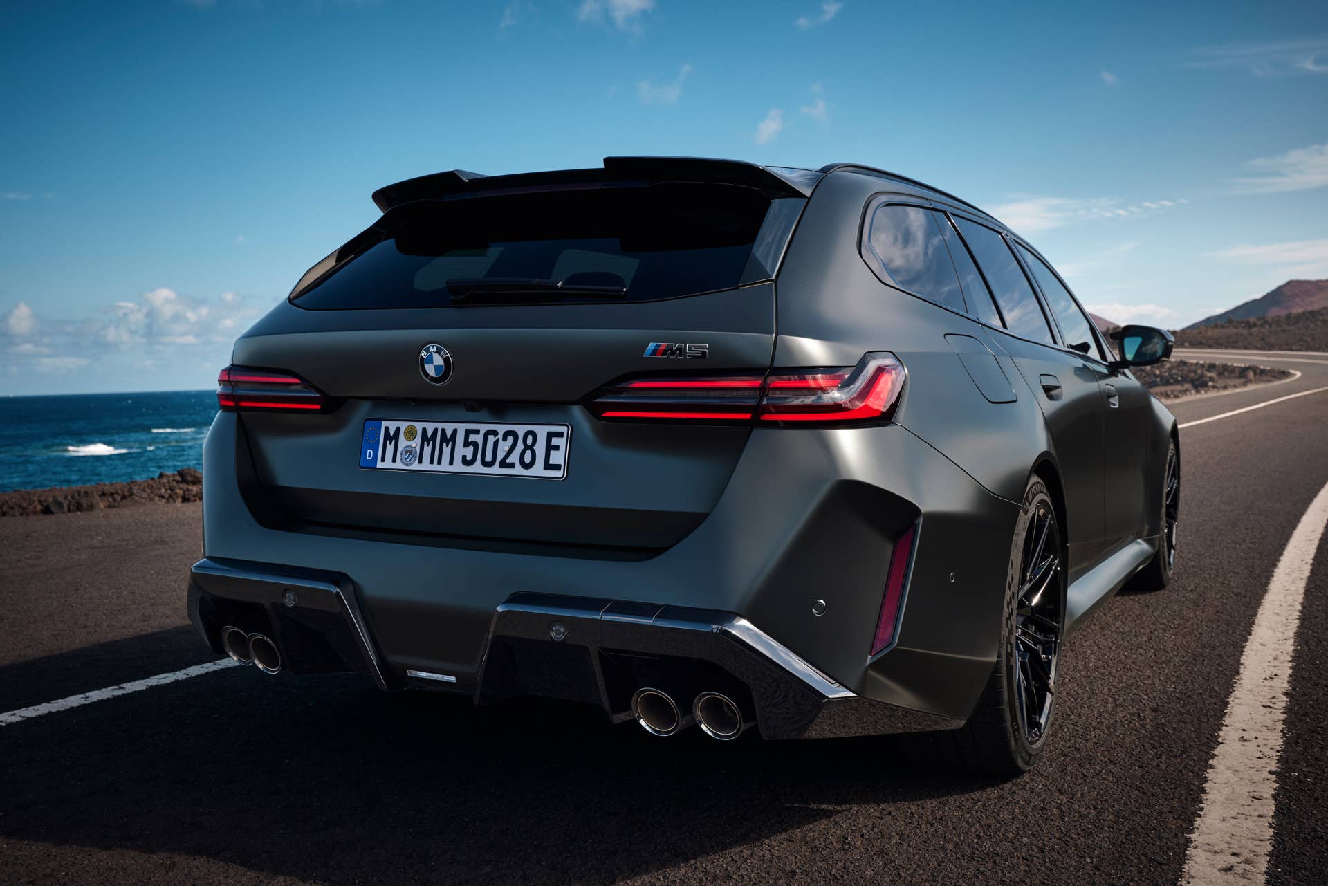 2026 BMW M5 Touring in BMW Individual Frozen Deep Grey rear view driving