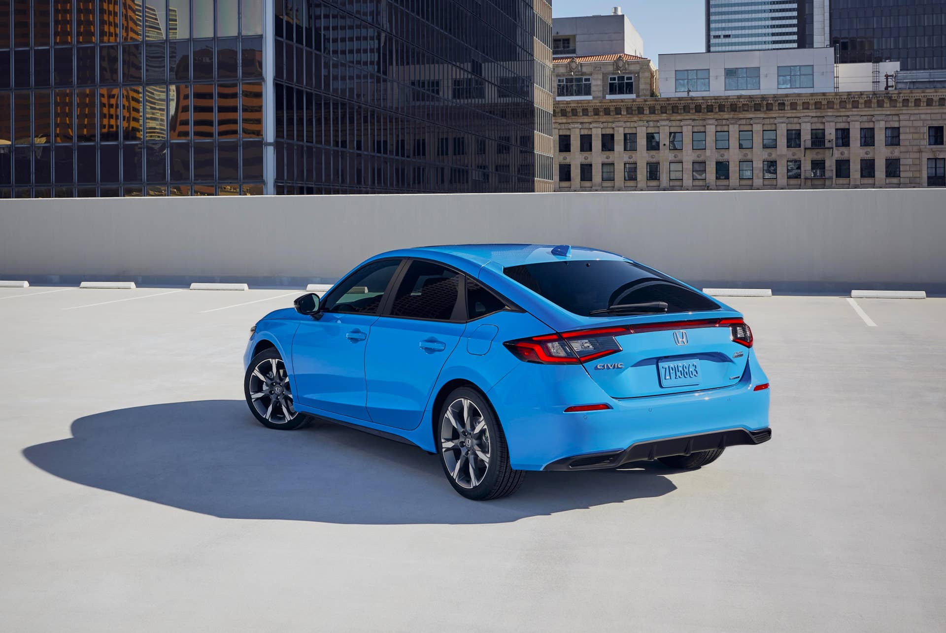 2025-2026 Honda Civic Hatchback Sport Touring Hybrid in Boost Blue Pearl rear angled view