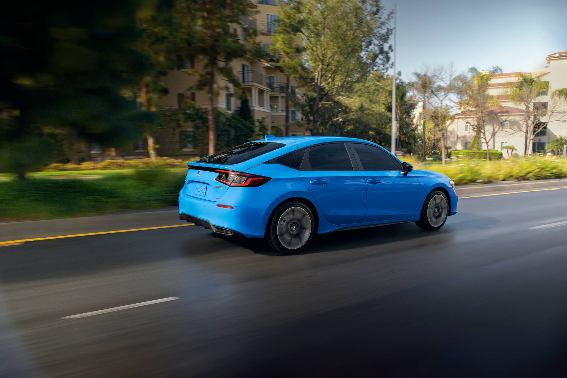 A rolling shot of the 2025 Honda Civic Hatchback Hybrid