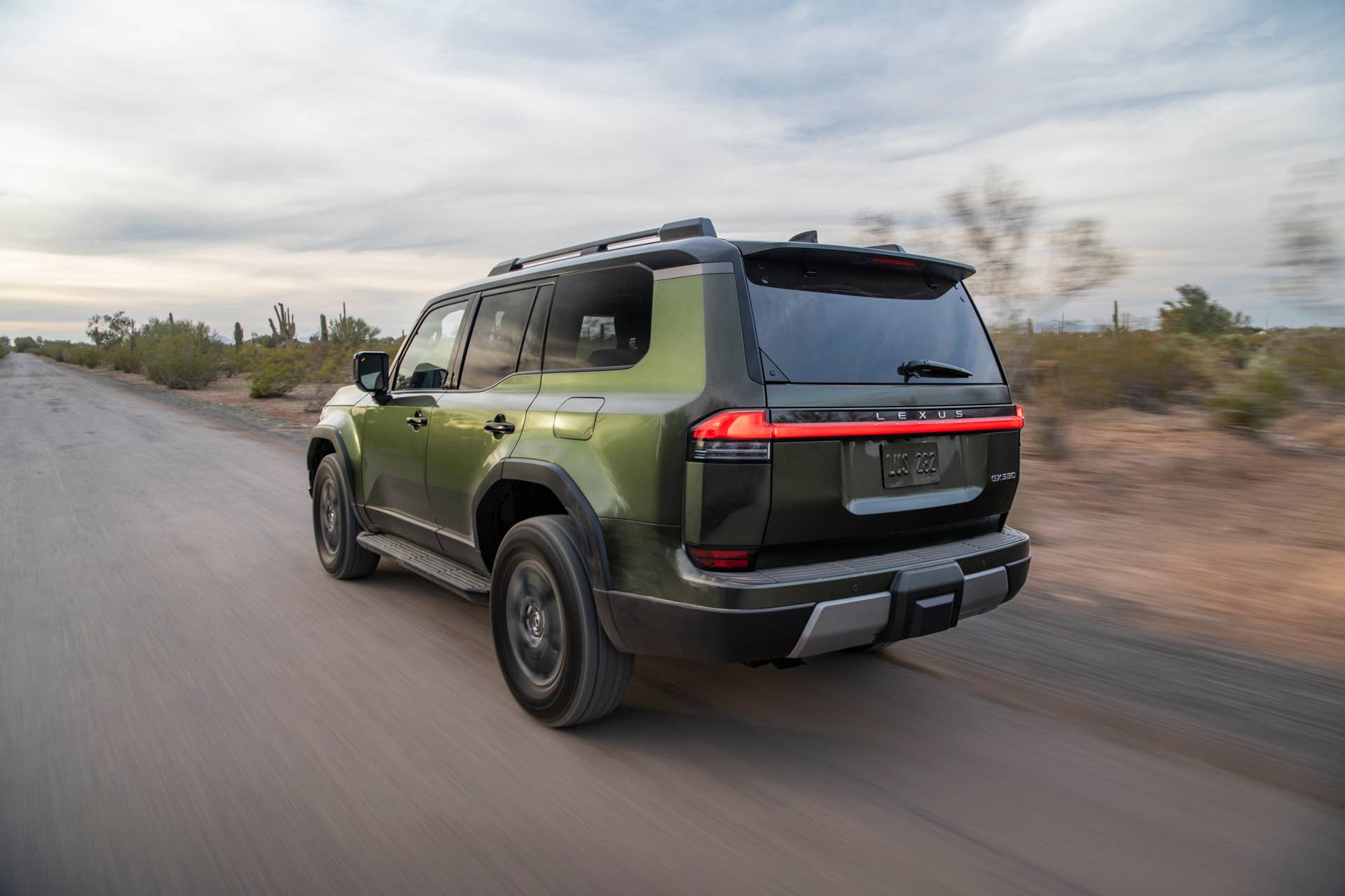 2026 Lexus GX Overtrail in Nori Green rear angled view driving