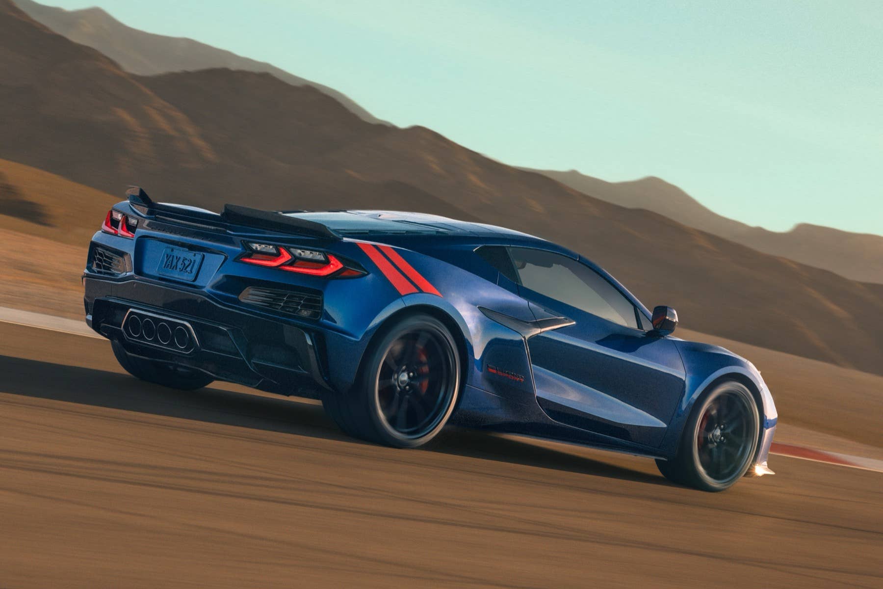 2027-Chevrolet-Corvette-Grand-Sport-Coupe-Press-Photos-Admiral-Blue-Metallic-White-Stripe-Red-Hash-Marks-Exterior-012-rear-three-quarters-driving