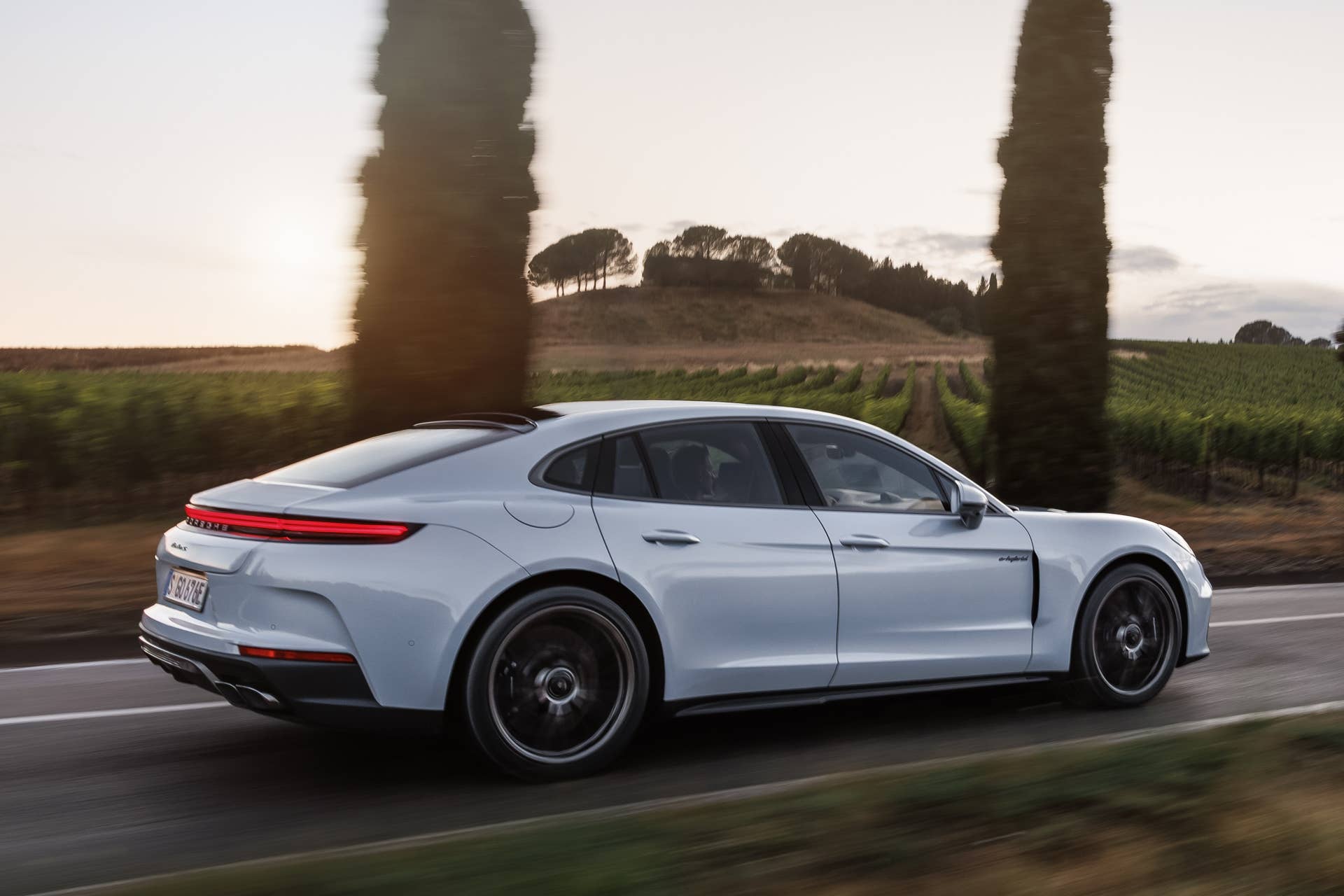 2026 Porsche Panamera Turbo S E-Hybrid silver rear angled view driving