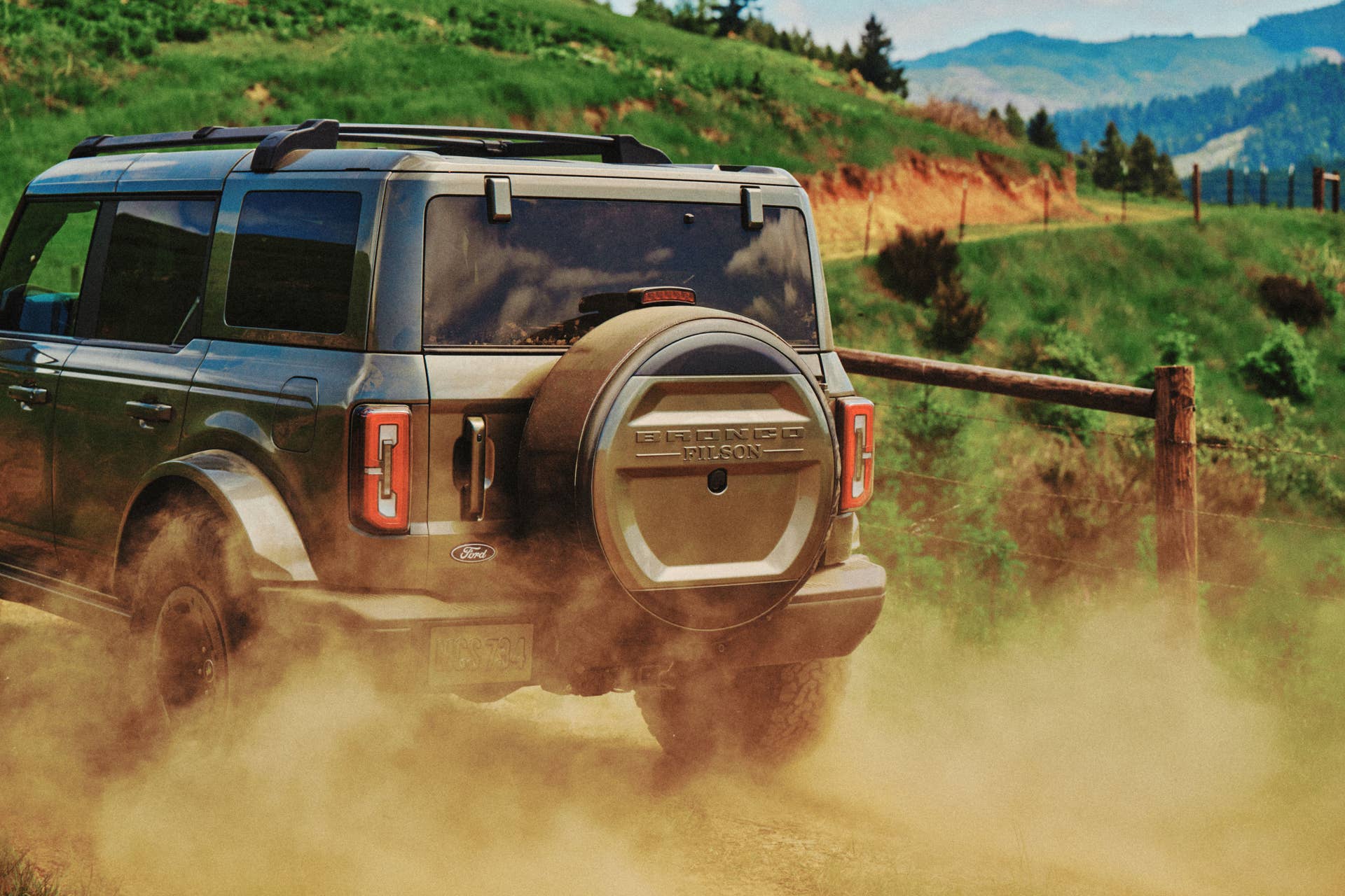 2027 Ford Bronco Filson green rear angled view dust driving