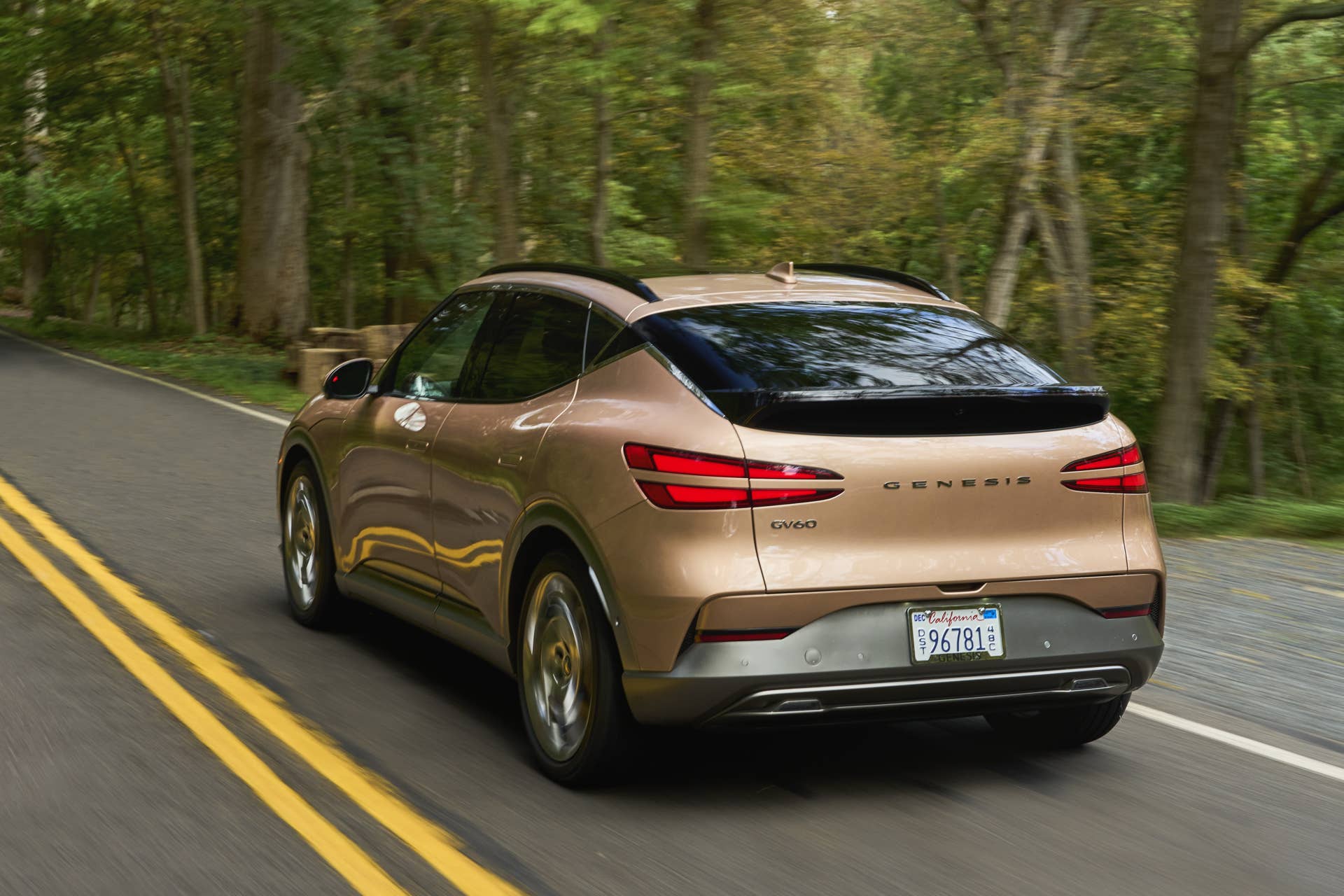 2025 Genesis GV60 gold rear angled view driving