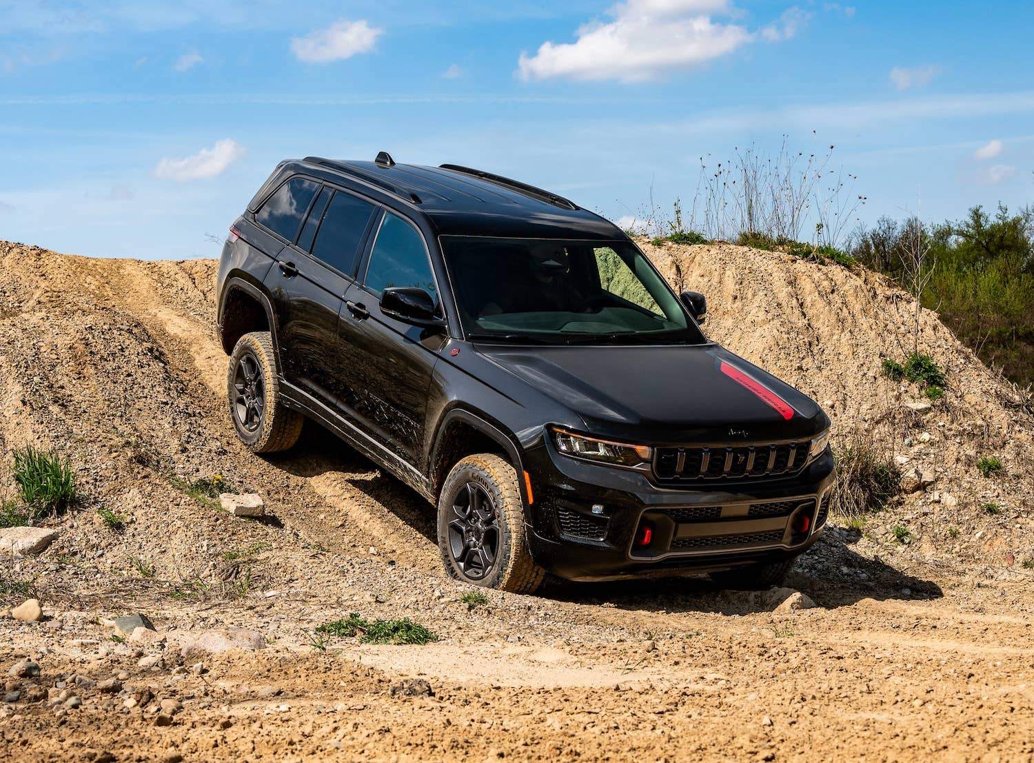 2027 Jeep® Grand Cherokee Trailhawk in black front angled view off-road driving