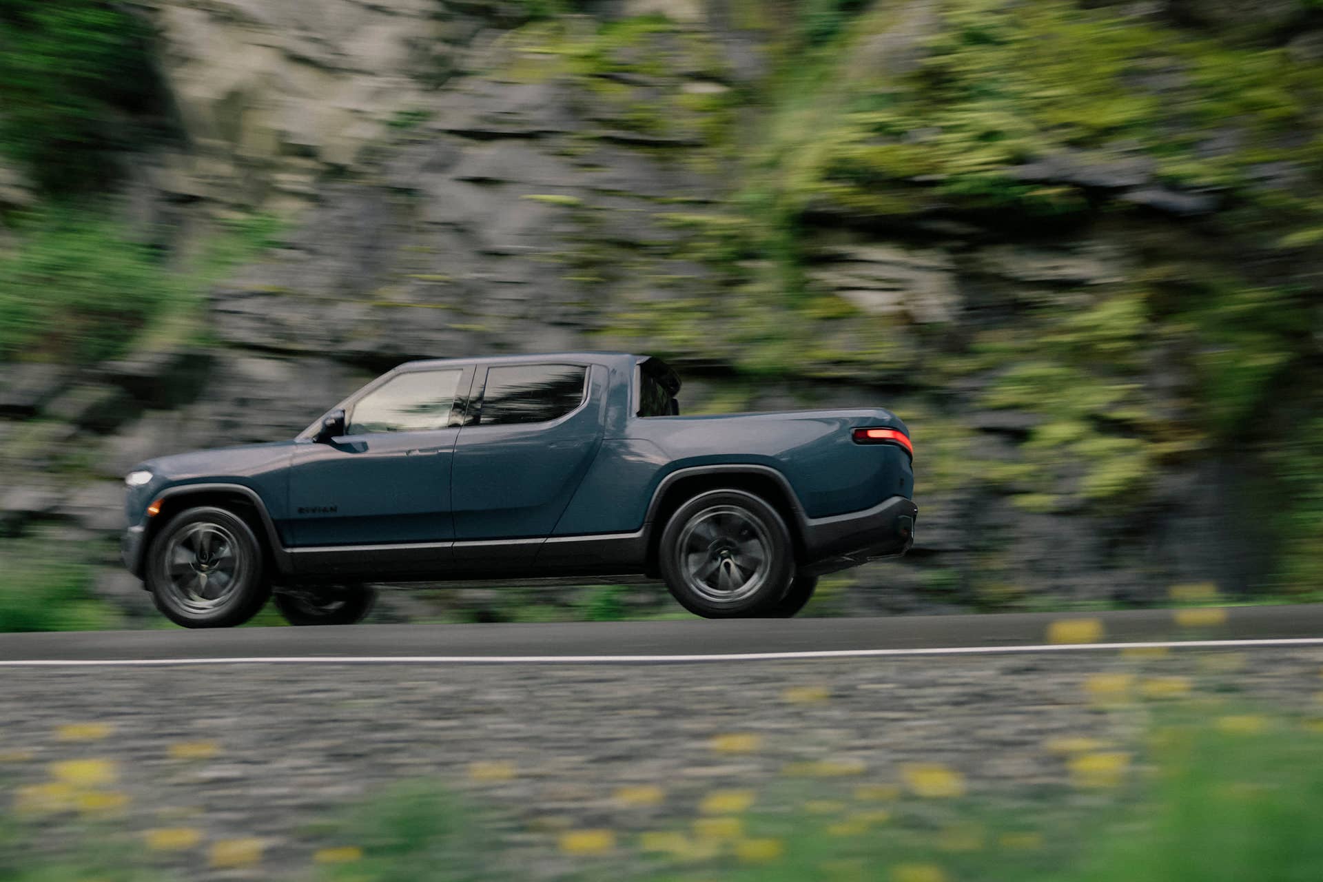 2025-2026 Rivian R1T in Storm Blue side view driving