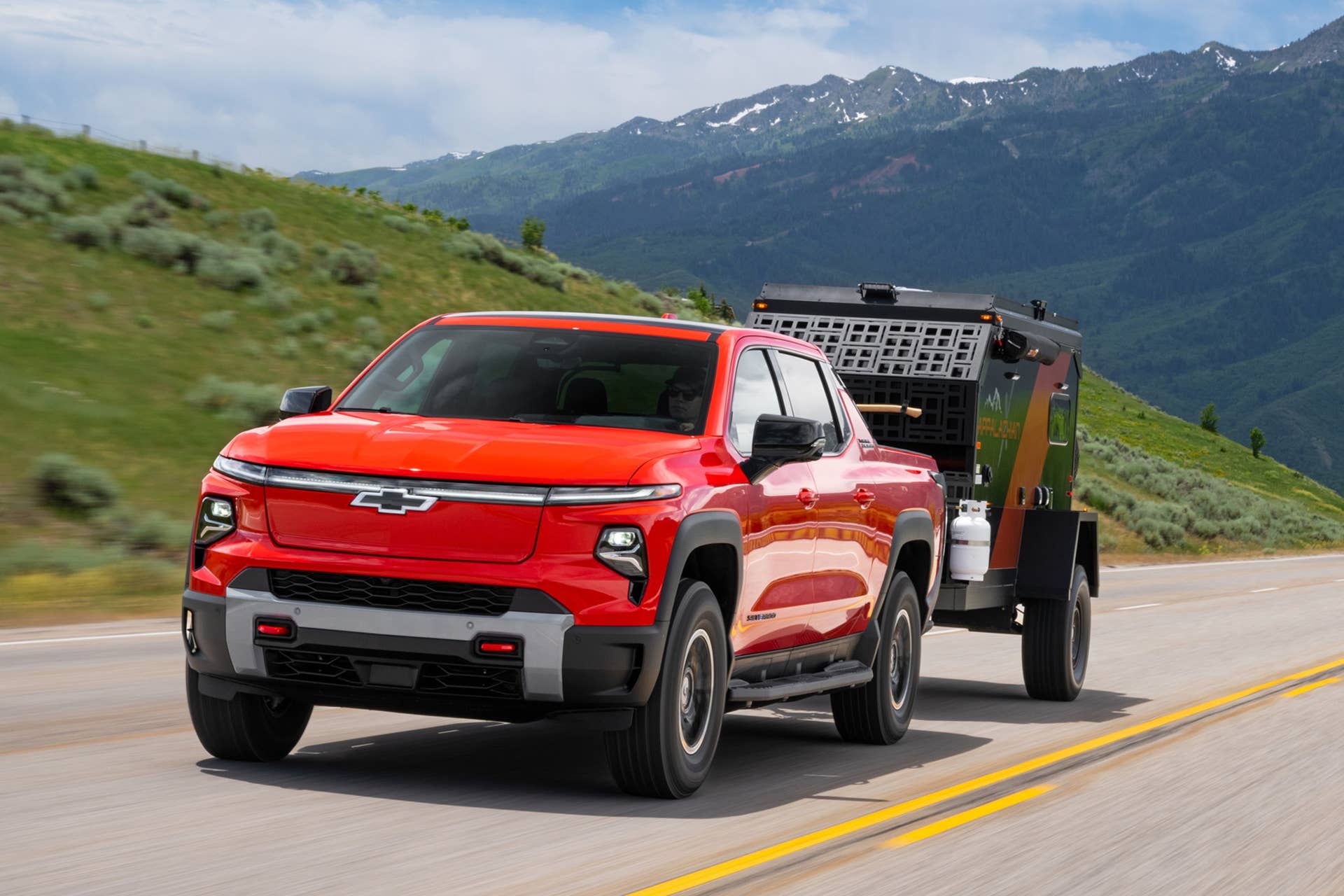 2026 Chevrolet Silverado EV Trail Boss in Habanero Orange front angled view towing