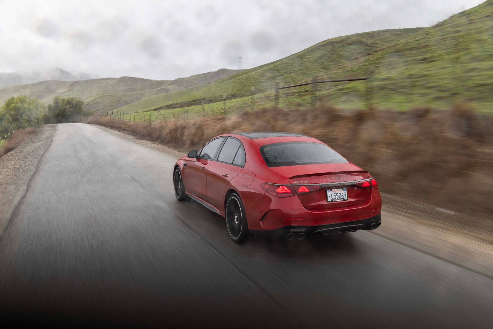 2026 Mercedes-AMG E 53 Sedan in Manufaktur Patagonia Red rear angled view driving