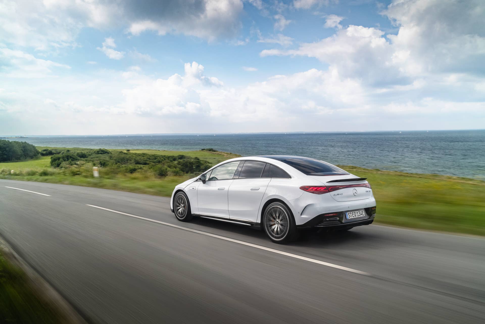 2025-2026 Mercedes-AMG EQE in white rear angled view driving