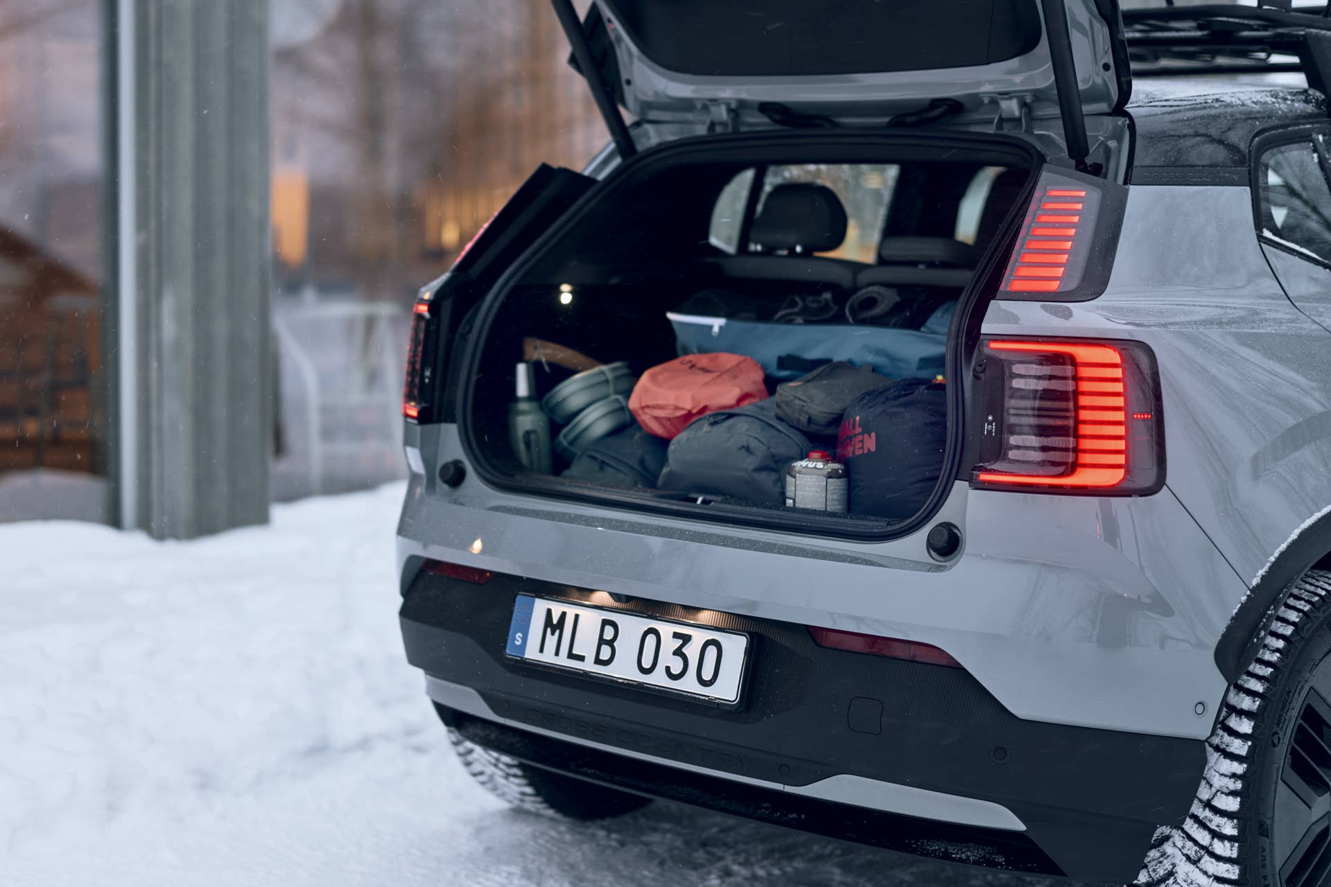 2026 Volvo EX30 Cross Country in gray rear angled view on snow trunk open