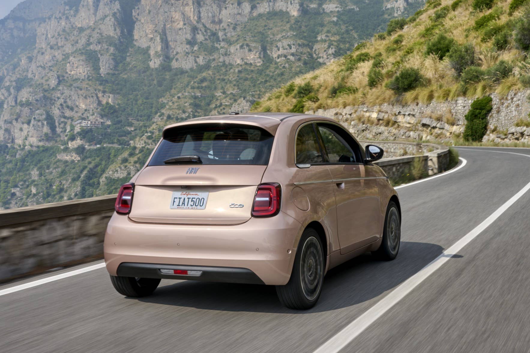 2026 Fiat 500e Icona in Rose Gold rear angled view driving