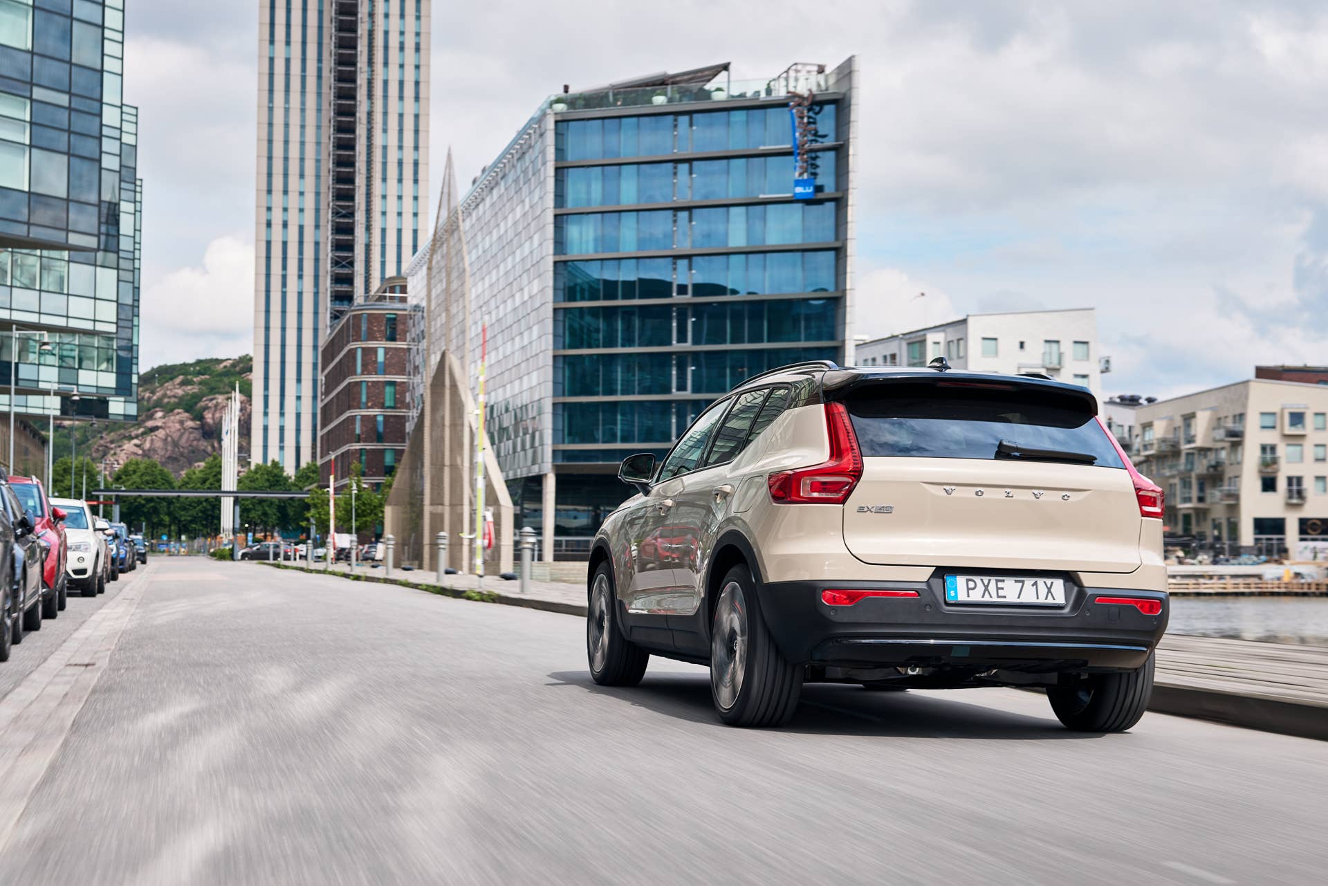 2025-2026 Volvo EX40 in Sand Dune rear angled view driving