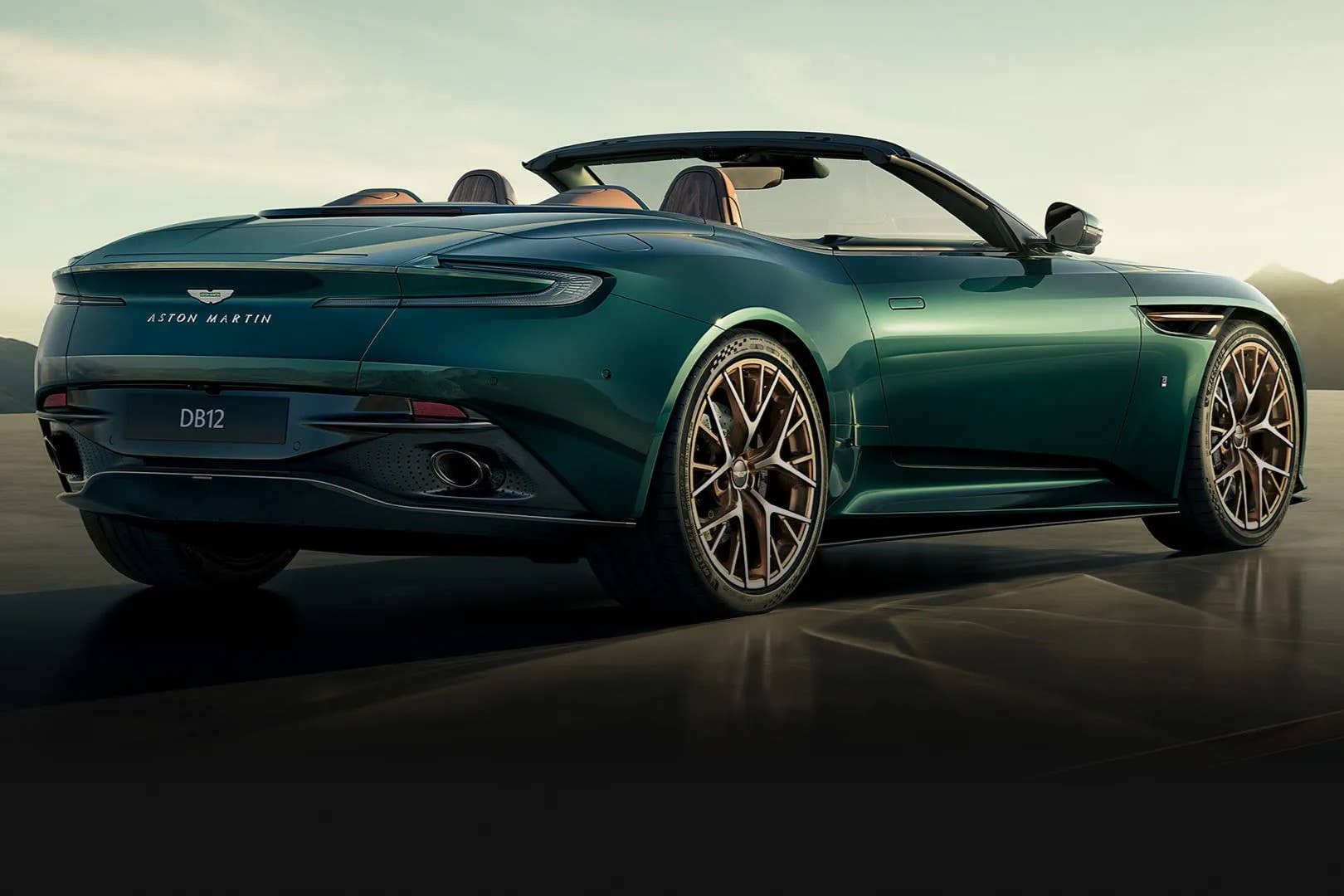 2026 Aston Martin DB12 Volante 60th Anniversary Edition top down in green rear angled view