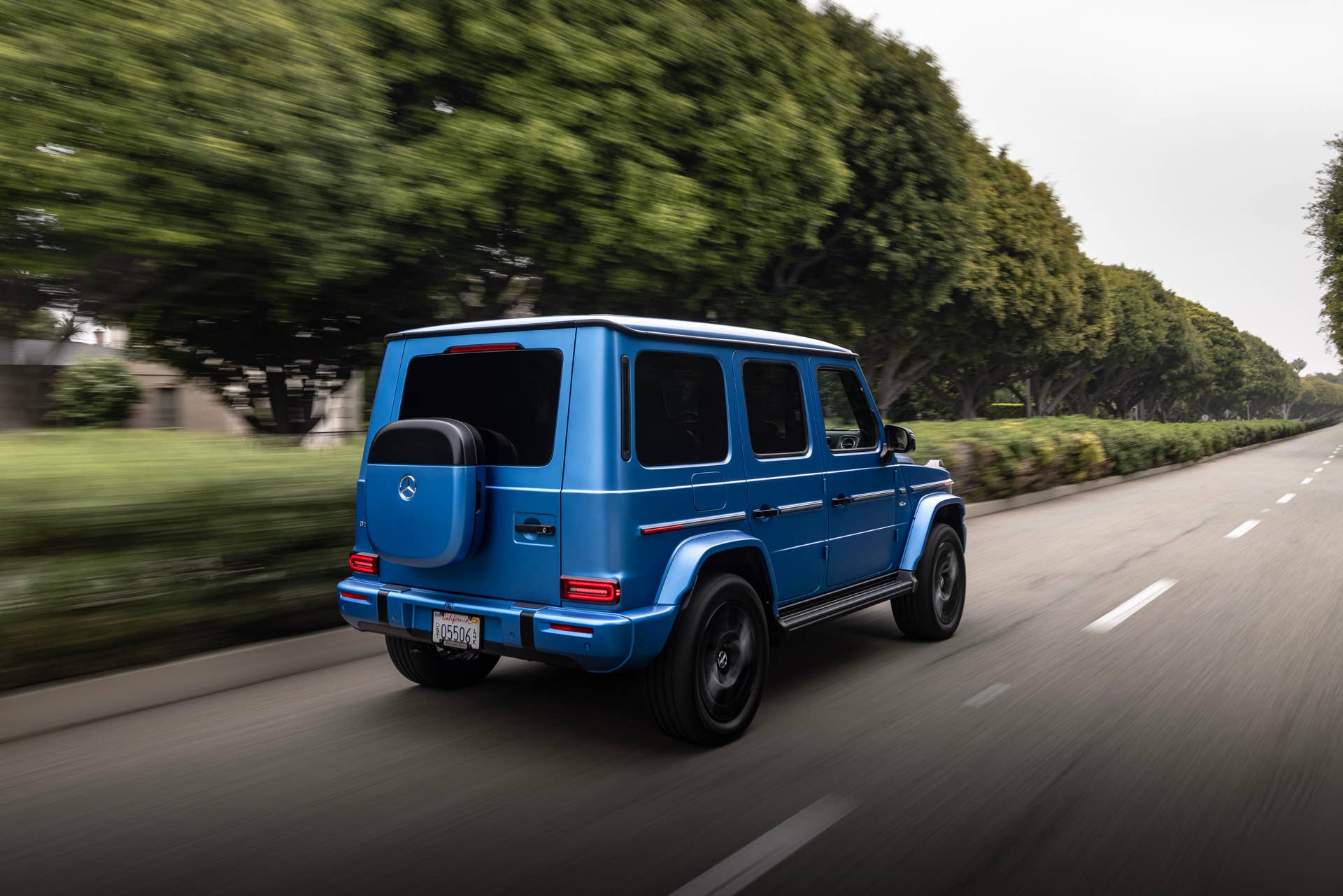 2025-2026 Mercedes-Benz G-Class EV in blue rear angled view driving