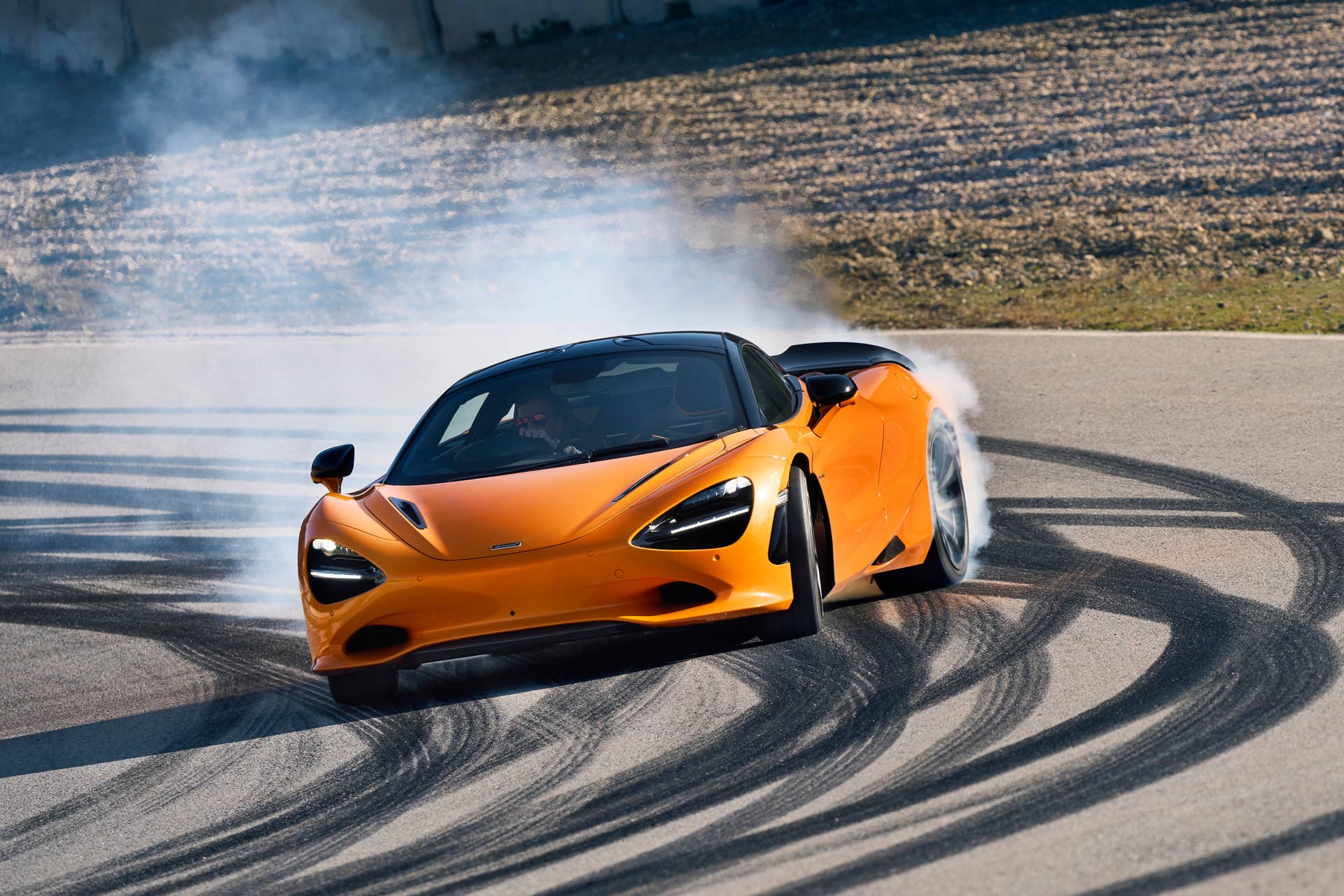 2025-2026 McLaren 750S in orange front view smoky oversteer