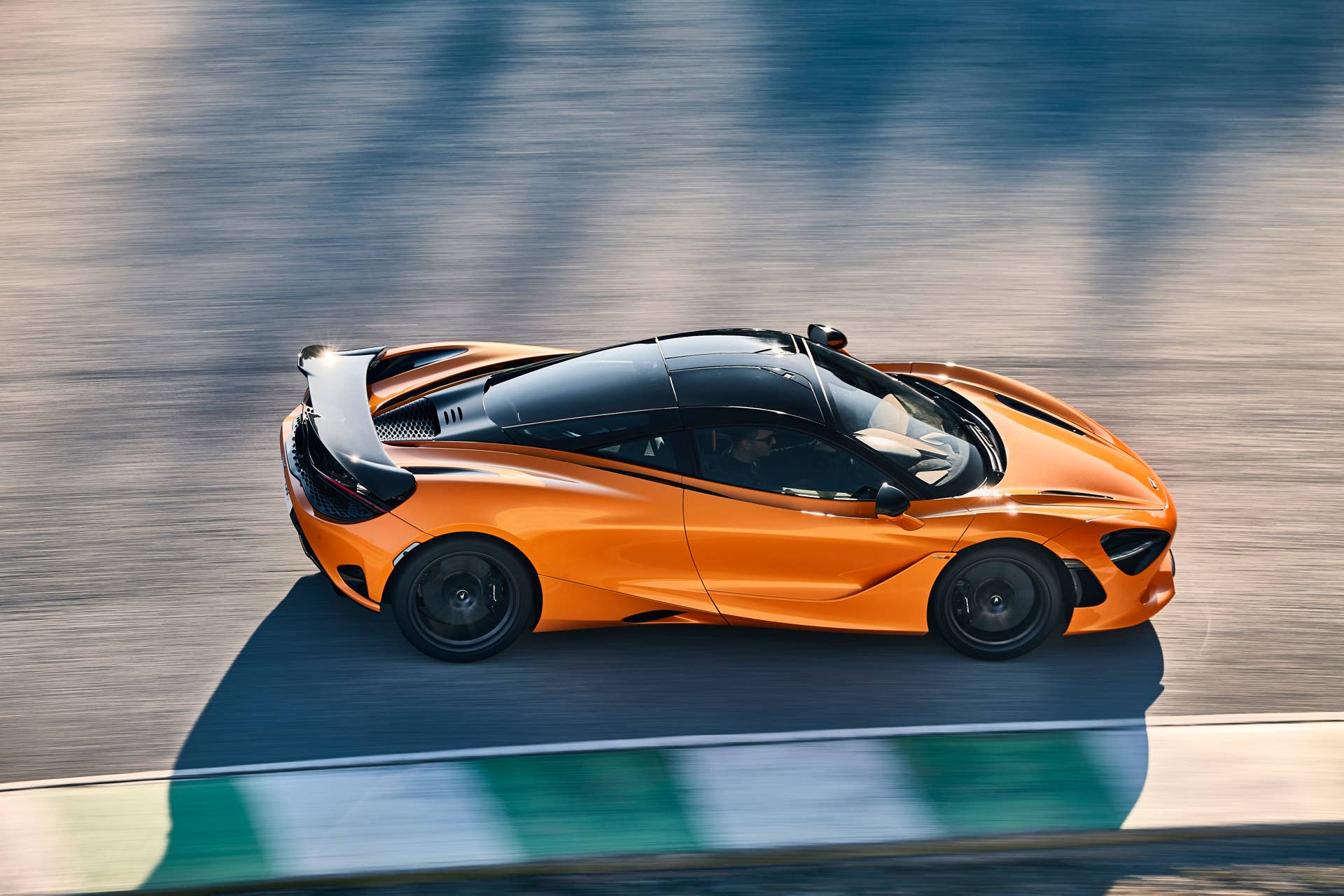 2025-2026 McLaren 750S in orange high side view track driving