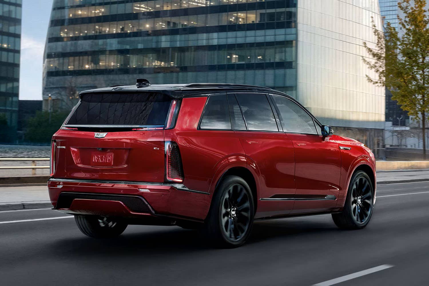 2027 Cadillac Vistiq Platinum in Radiant Red Tintcoat rear angled view driving