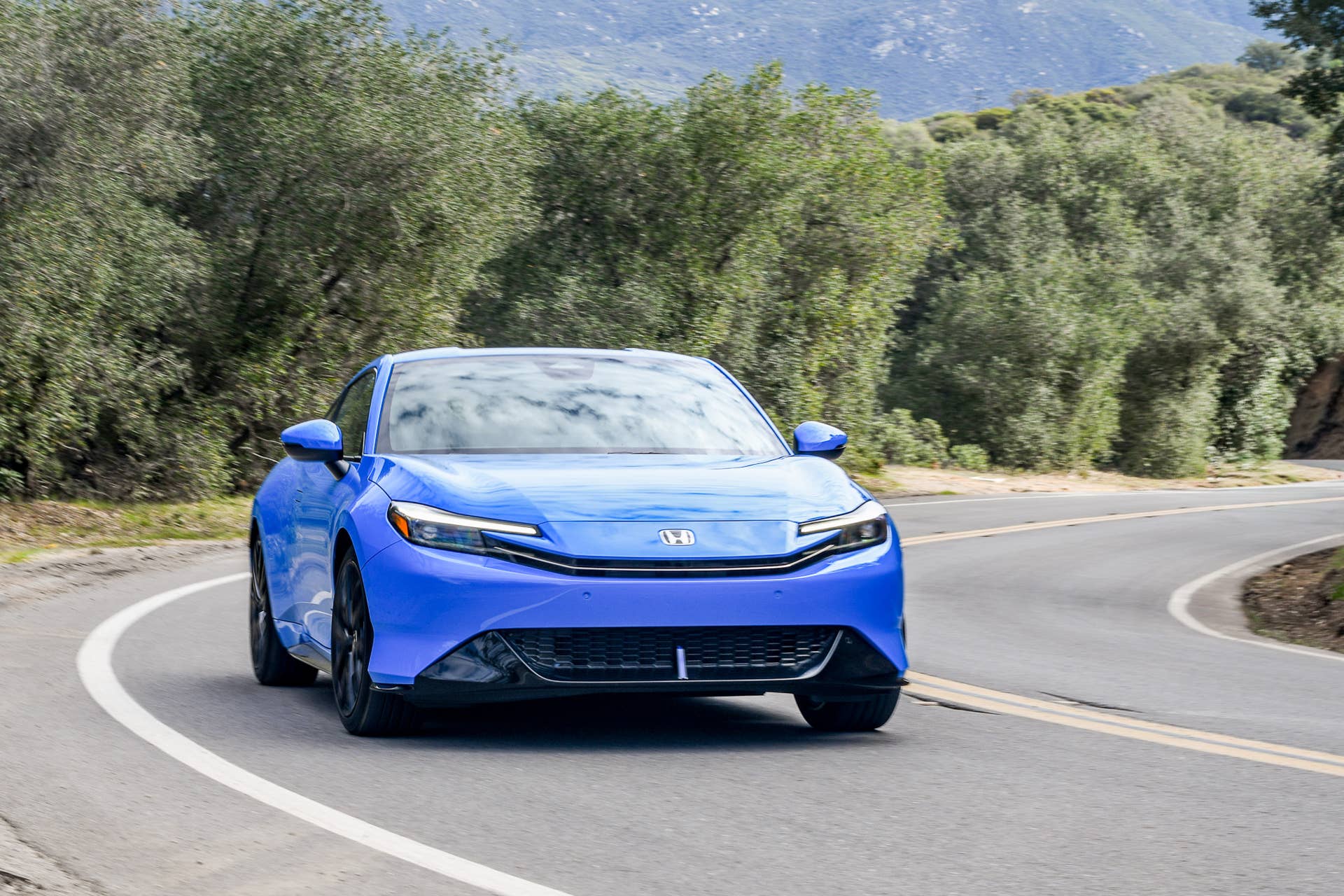 The 2027 Honda Prelude driving on a windy road