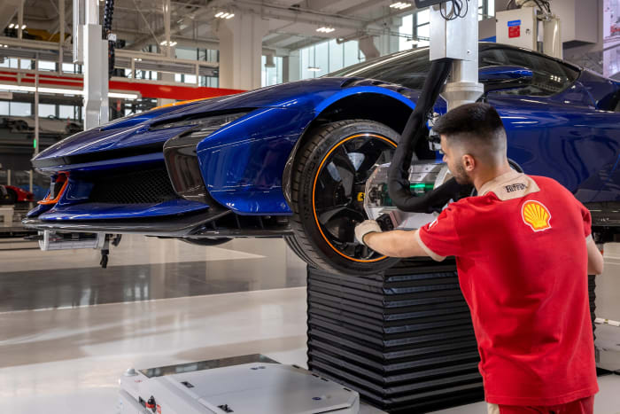 The driver's side wheel of a Ferrari GTB gets some special attention by a factory worker