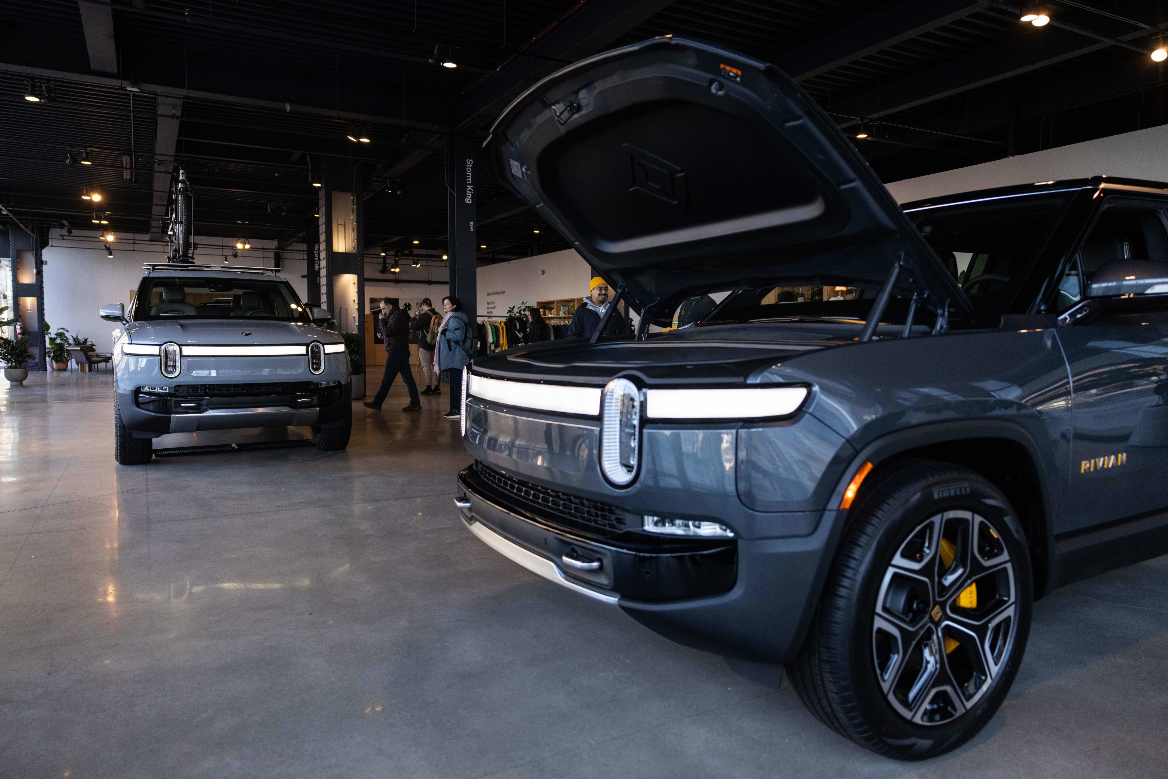 A Rivian R1T electric vehicle (EV) pickup truck, left, and R1S electric sports utility vehicle (SUV) at the company's showroom in New York, US, on Tuesday, Jan. 2, 2024.