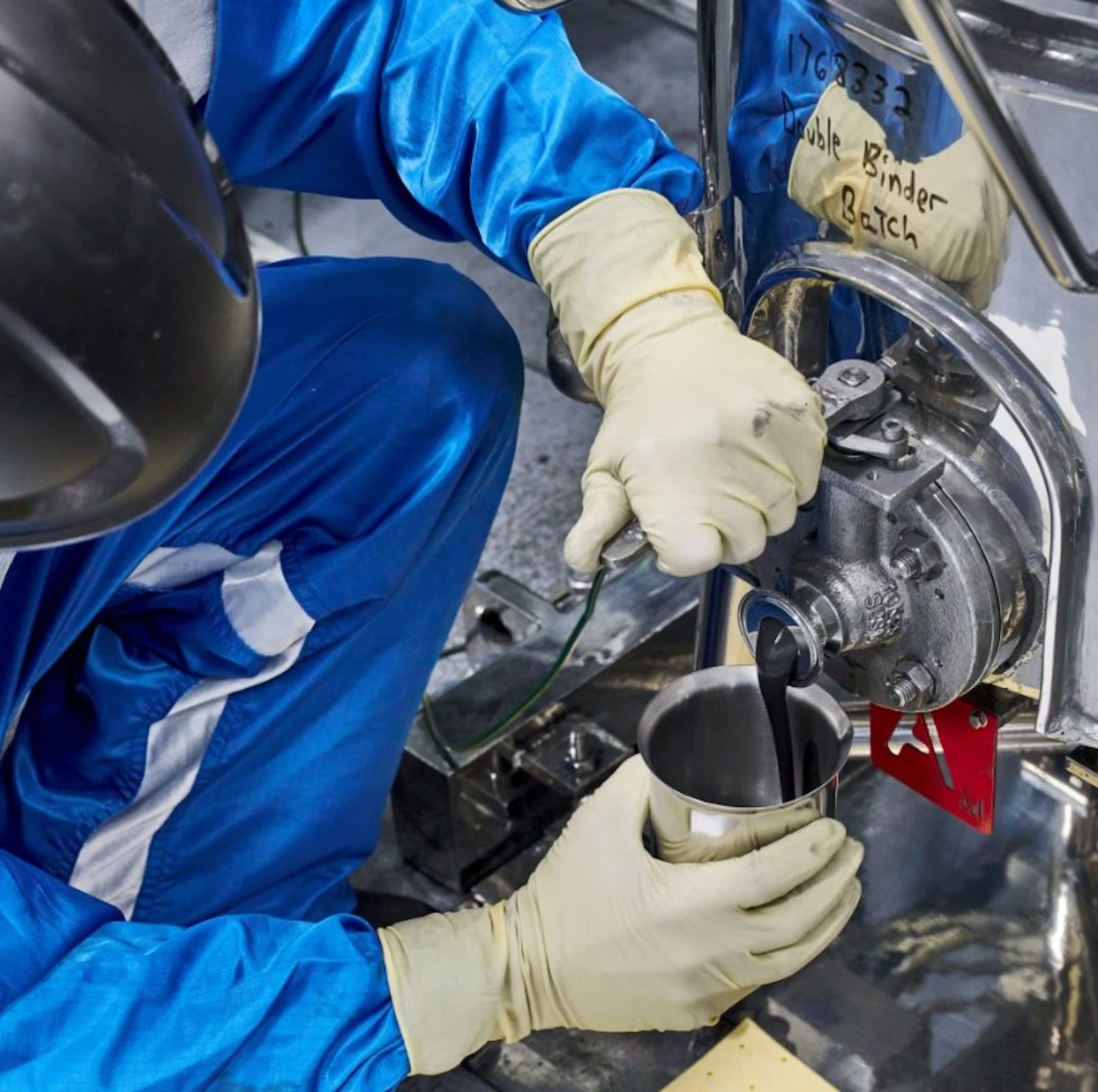 A battery technician at the General Motors Wallace Battery Cell Innovation Center takes a chemistry slurry sample