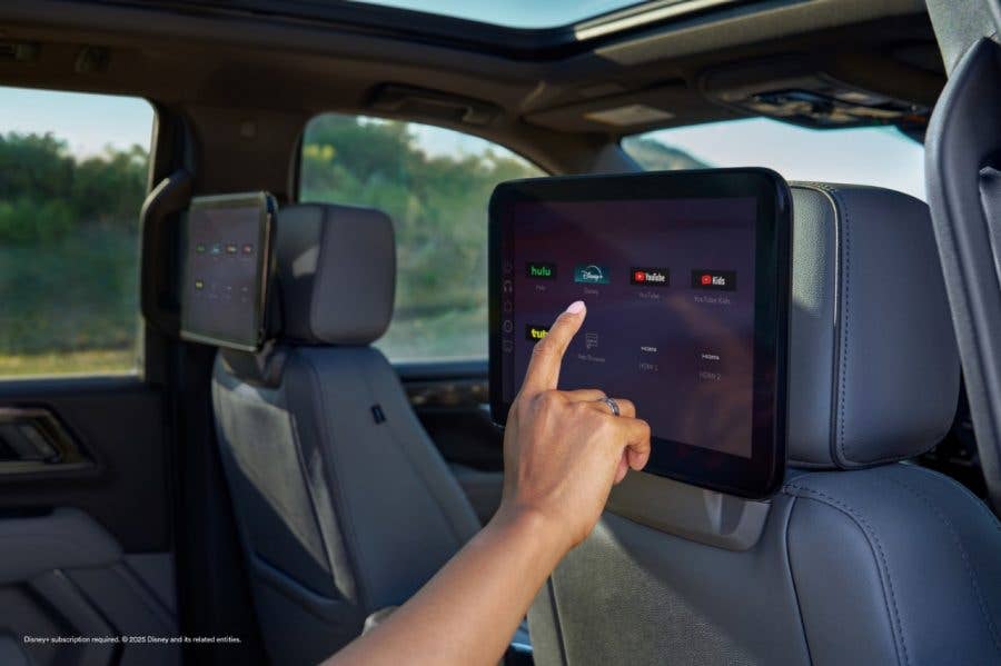 Finger pointing to Disney+ app streaming GM SUVs